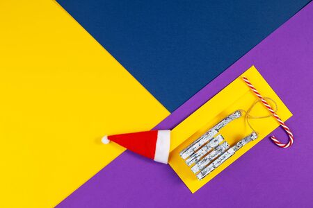 Geometric Xmas background on trendy colored paper. Above view of multicolored geometric layered paper background in yellow, blue, purple. Christmas, New Year, winter conceptの写真素材