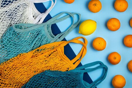 Zero waste concept. Textile eco bags with tangerines on blue backgroundの写真素材