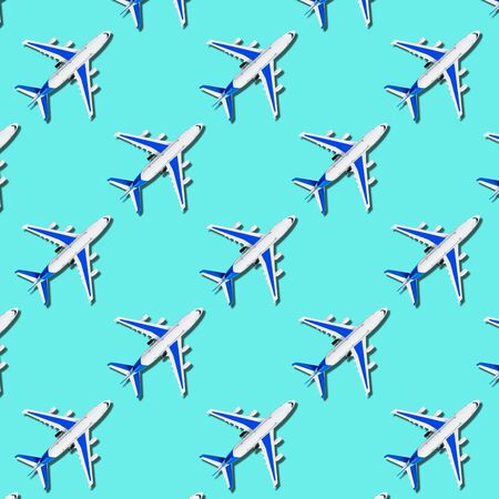 Pattern, seamless model airplane texture, plane on blue background. Summer travel or vacation pattern. Creative composition made with passenger plane on pastel pink background. Top view, flat lay.の写真素材