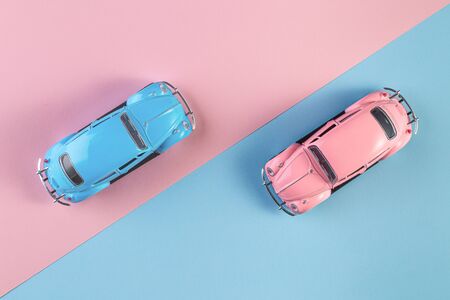 Izhevsk, Russia, February 15, 2020. Small vintage retro toy cars on a pink and blue background. Racing cars on the race track. concept for competition or childhood. winner and loser concept.の写真素材