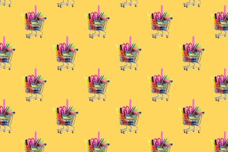 Seamless pattern. Shopping cart with School stationery on a yellow background.の写真素材