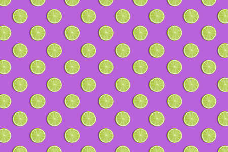 Colorful fruit seamless pattern of fresh lime slices on a purple background. Trendy sunlight Summer pattern. Minimal summer concept. flat lay food textureの写真素材