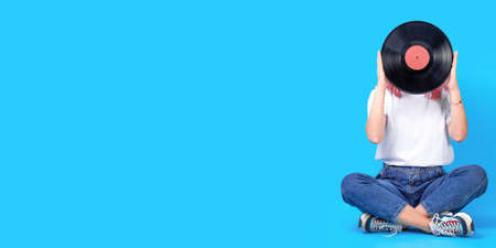 Woman dj portrait with vinyl record against blue background.の写真素材