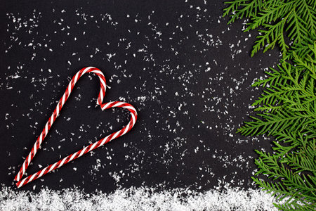 Green Chrristmas tree made of coniferous tree branches and snowflakes on a dark