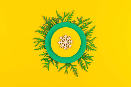 Christmas composition with coniferous tree branches on yellow paper background. Top view. New year concept.の写真素材