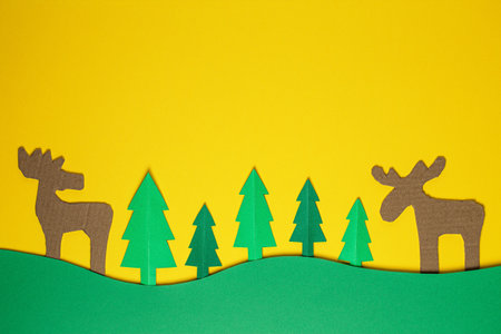 Christmas tree paper cutting design papercraft card. Paper cut Christmas trees and deer. Creative design of christmas background with paper fir tree. paper craft.の写真素材