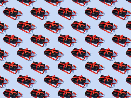Seamless pattern made of gift boxes tied with white ribbons on yellow background. Creative Christmas...