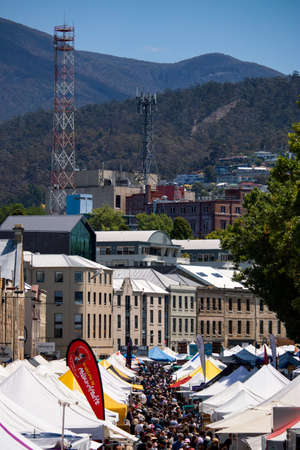 Dense crowds surrounding outdoor market tents in a country townのeditorial素材