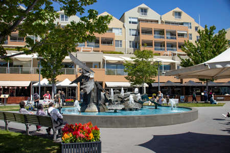 Fountain in a town square surrounded by tourists and colorful plantsのeditorial素材