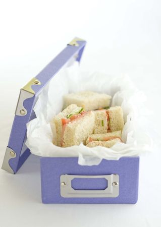 Cucumber and tomato sandwiches on white bread in creative purple box.の写真素材