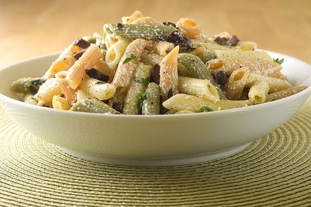 Bowl of penne pasta with balck olives, fresh herbs and parmesan.の写真素材