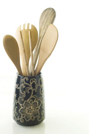 Wooden utensils in black vase on white background.の写真素材