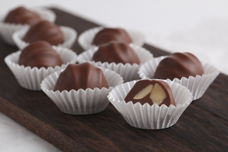 Chocolate truffles in wrapper on dark wood boardの写真素材