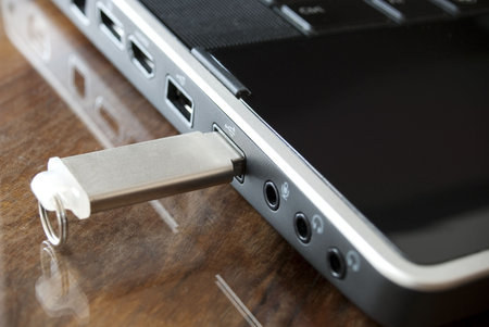 a black laptop and a pen drive