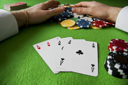 winning many chips with poker of aces on a gambling table