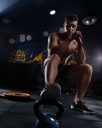 Muscular man showing muscles isolated on the wall background. Strong male naked torso abs, creative photo, beautiful body, physique, relief, sexy guy, young.の写真素材