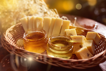 a jar of sweet honey with cheese and roses and fresh bread with bright light beautiful decoration creative photo in a bucket on a wooden table in the garden with flowers for breakfast delicious food. High quality photoの写真素材
