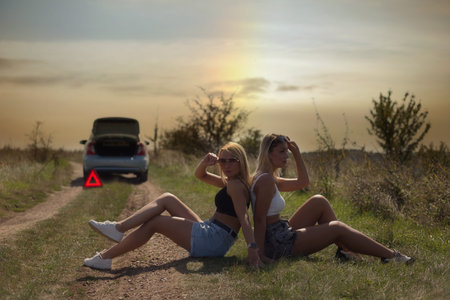 an accident on the road, a car broke down, two beautiful girl models are waiting for help. Car...