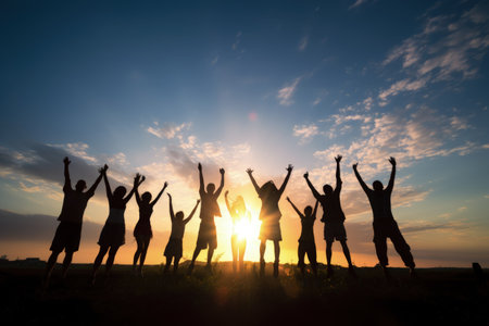 Peak triumph: silhouettes a top mountain, joyous group celebrates team success, embodying shared victories, harmonious collaboration, euphoria of collective achievement in nature's majestic embraceの素材