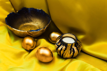 On the yellow fabric, there is a beautiful handmade plate in vintage style, painted in gold and...