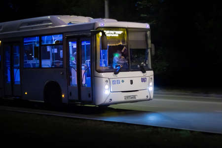 White bus in motion on the evening road