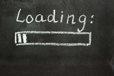The loading process is shown in white on a chalkboard. Stop motion animation. Black backgroundの写真素材