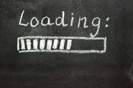 The loading process is shown in white on a chalkboard. Stop motion animation. Black backgroundの写真素材