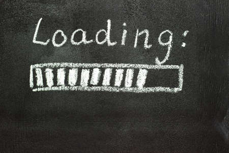 The loading process is shown in white on a chalkboard. Stop motion animation. Black backgroundの写真素材