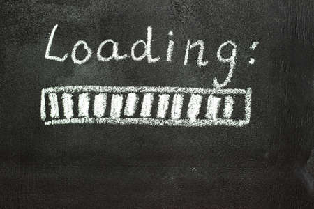 The loading process is shown in white on a chalkboard. Stop motion animation. Black backgroundの写真素材
