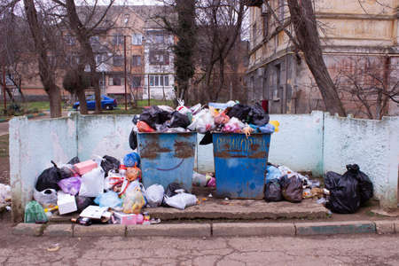 Full trash can. Trash can filled with trash. Trash can packed to overflowing with rubbish. The bin is filled with rubbish.の写真素材