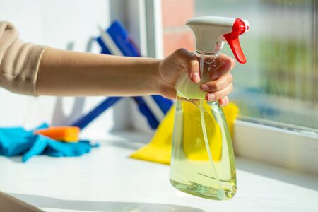 The girl took a solution for washing Windows. The girl is going to wash the window. Window washing,...