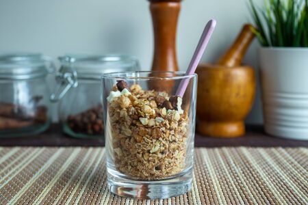 Healthy lifestyle. Healthy and nutritious muesli in a glass. For Breakfast, natural muesli with nuts. Muesli in a glass on a wooden tableの写真素材