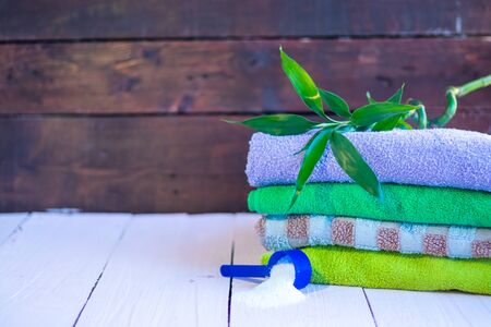 Washed towels and clothes on a wooden background. Cleaning the houseの写真素材