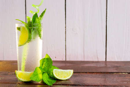 A glass of fresh Mojito. Lime and mint. On a wooden backgroundの写真素材