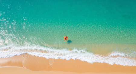 Aerial view of a tropical beach with turquoise water and a person on an inflatable ring, perfect for a travel blog and summer vibesの素材