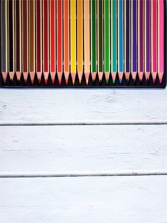 Set Of Colored Pencils In A Box On White wooden Backgroundの写真素材