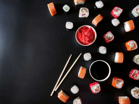 laying sushi, ginger, sauce on a black background. High quality photo with copy space
