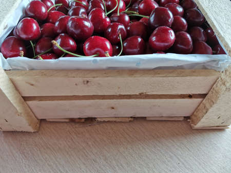 on the table is a full box of red cherriesの写真素材