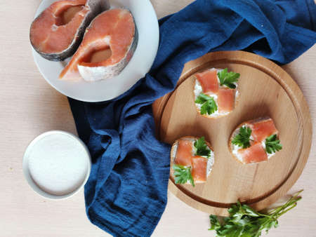 beautiful layout of sandwiches with red fish, ingredients and blue textileの写真素材