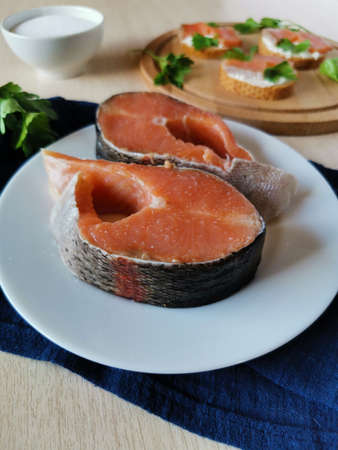 slices of red fish homemade salt on a white plate and sandwiches with herの写真素材