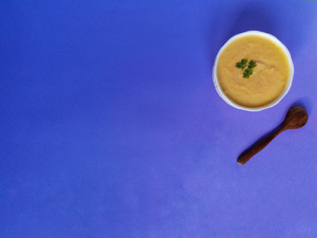 Vegetarian autumn pumpkin cream soup on blue backgroundの写真素材