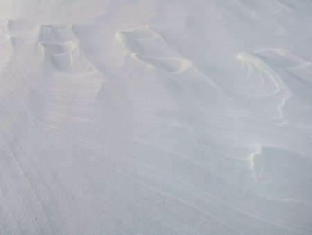 wind patterns on snow crust for white winter backgroundの写真素材