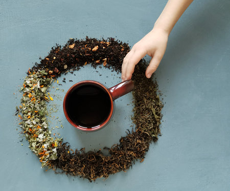 The childrens hand takes a mug of tea. Tea party conceptの写真素材