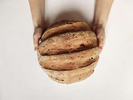 rye bread with sourdough at home. the woman holds it at arms lengthの写真素材
