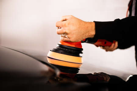 Close-up of a car detailing worker polishing a car with a polisherの写真素材