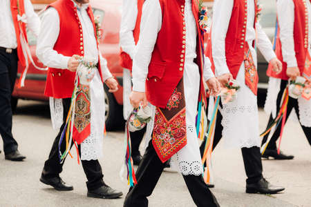 Group of men and women in national costumes with traditional embroidery on their backs.の写真素材