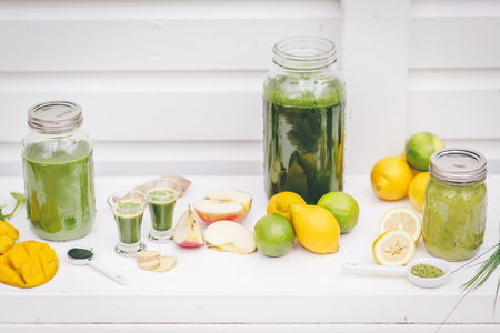 Different smoothies on the table, fruits and other ingredients.の写真素材