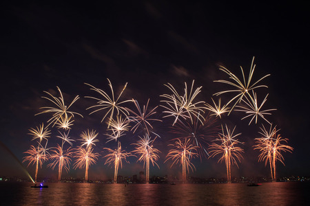 Colorful fireworks with reflection on lake and night sky in background.の写真素材