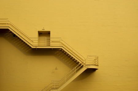 Stairs on a yellow building wallの写真素材