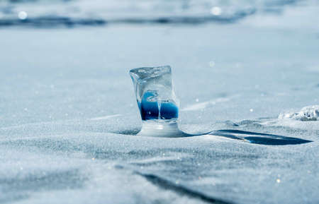 Piece of ice on a frozen lake under winter sunの写真素材